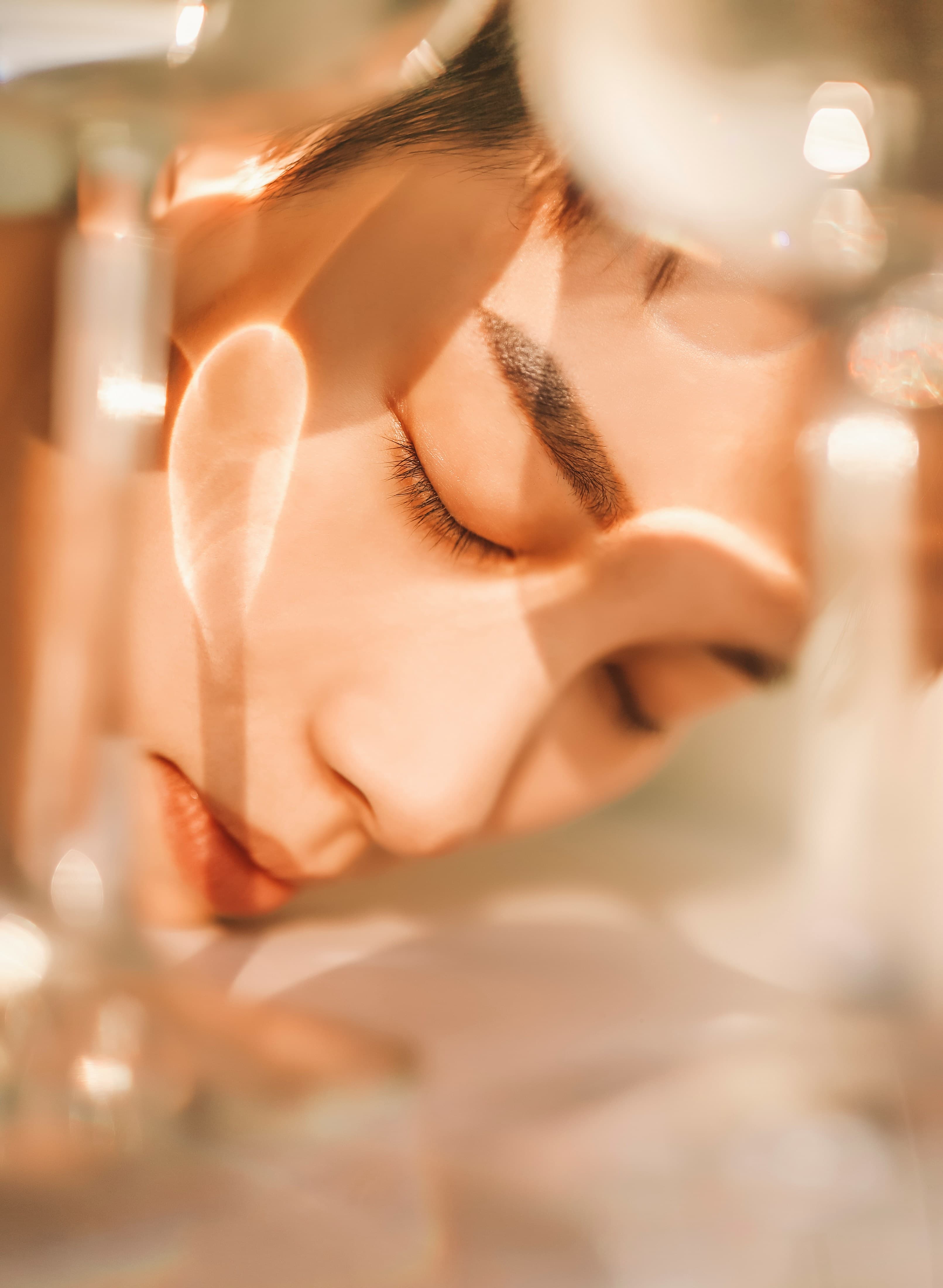 A woman resting with eyes closed in warm light — recovery from viral illness